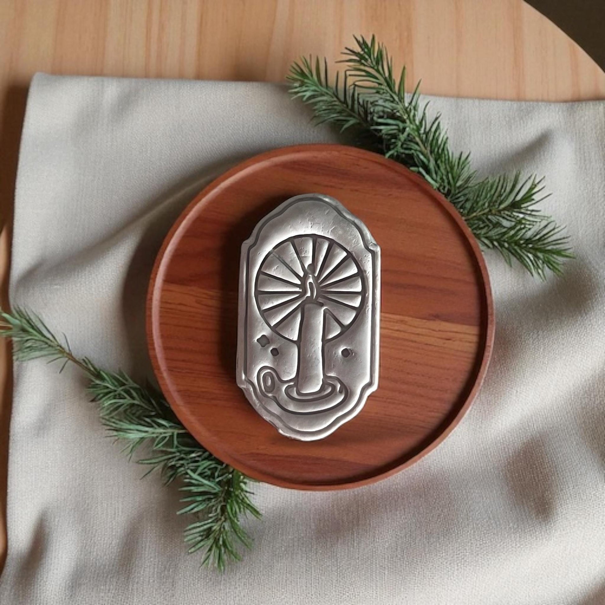 large candle window clay cutout on wooden tray with pine sprigs