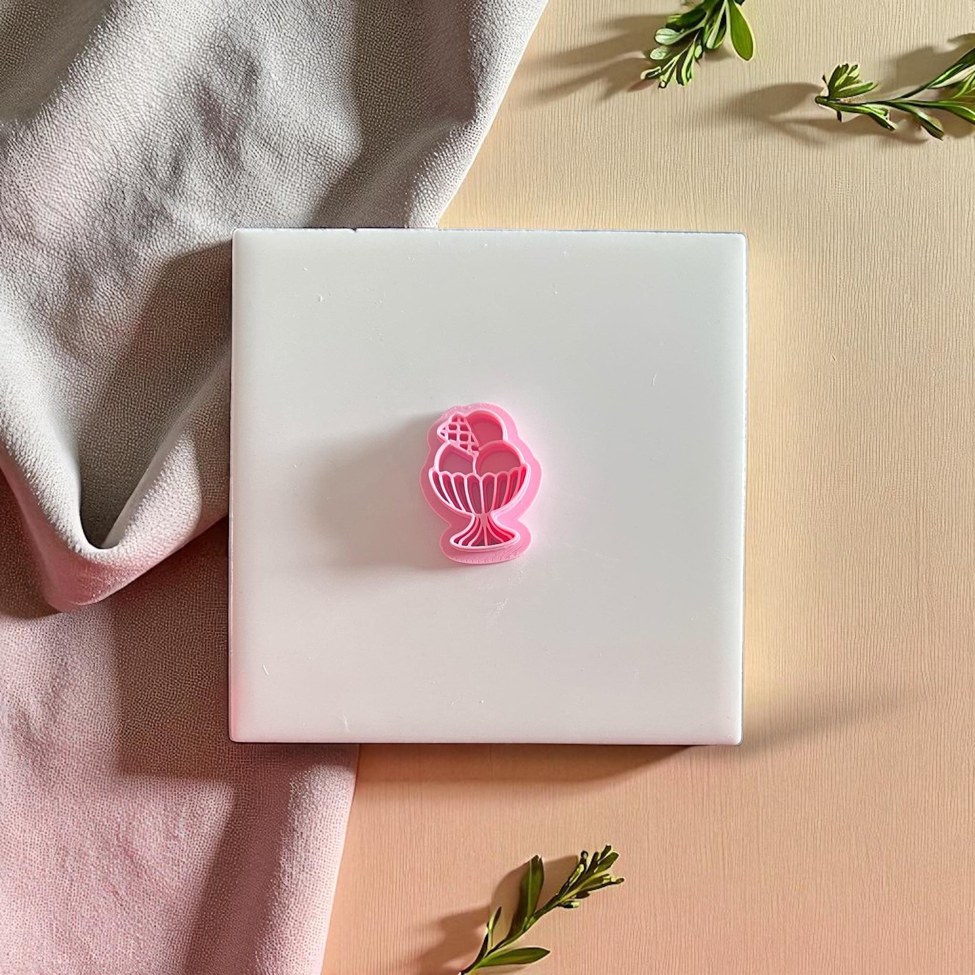 Sundae-shaped pink clay cutter on white background