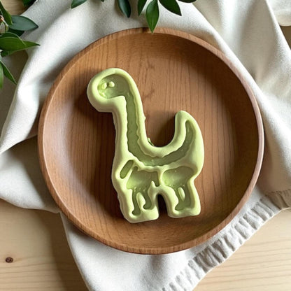 Large clay dinosaur cutout with full detailing shown in wood tray