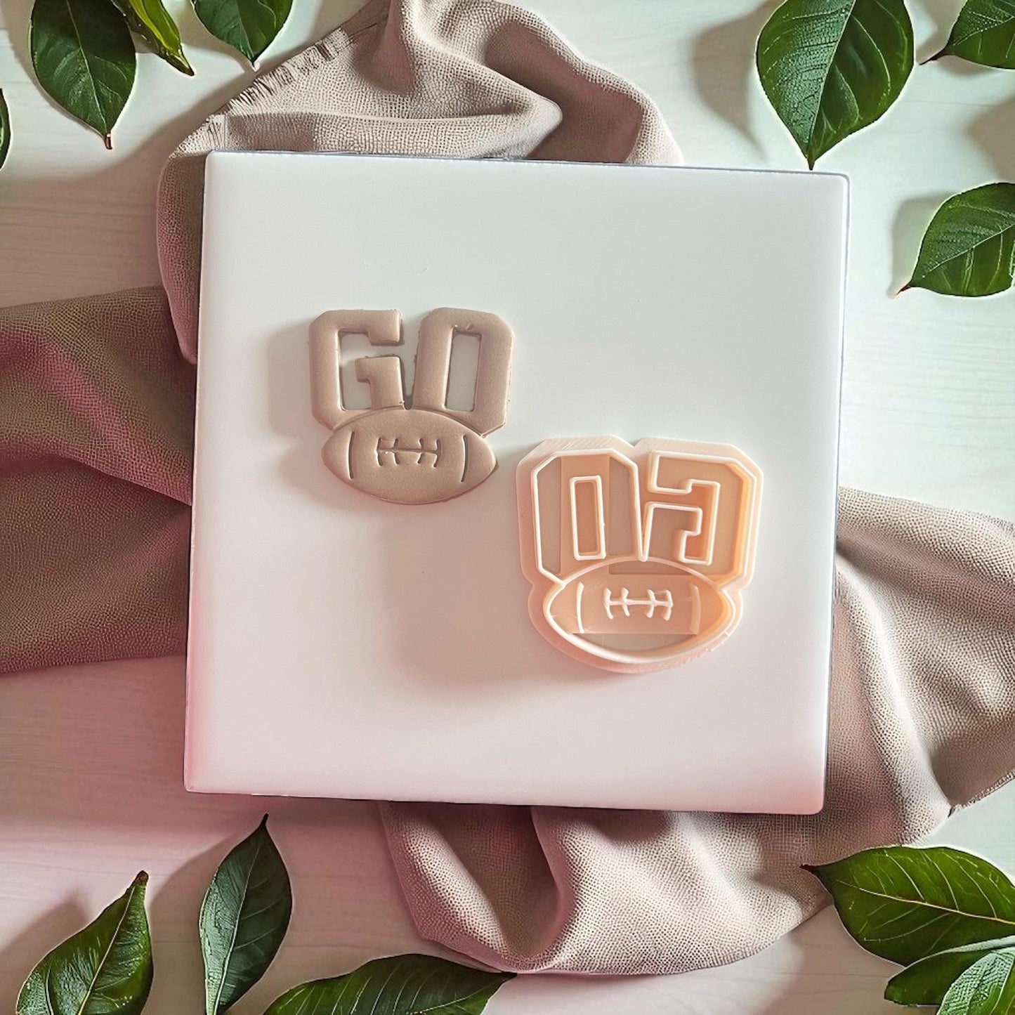 GO football clay impression beside matching cutter tool on soft fabric