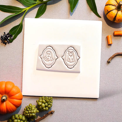 Mr. and Mrs. ghost cutters pressed in clay on white tile with pumpkins and greenery