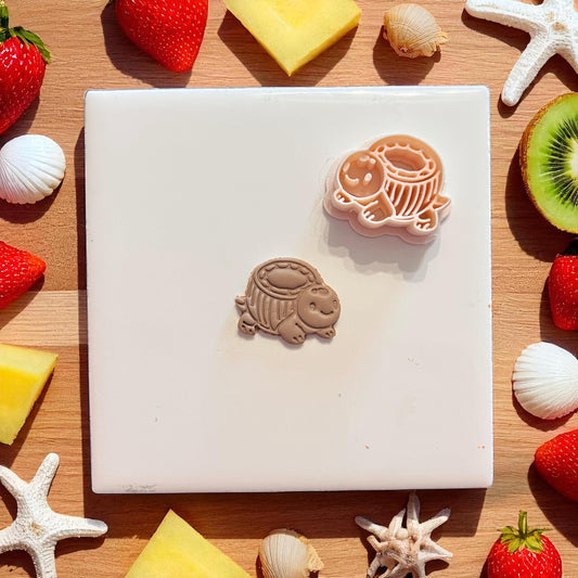 Polymer clay cutter and imprint of coconut turtle with seashells and kiwi