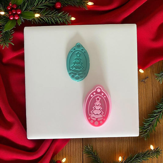 Teal and pink ornament-shaped tree cutters side by side on tile