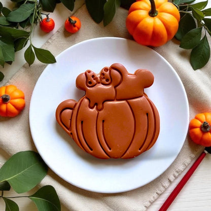 Large pumpkin drink cutout on a white plate with fall foliage and cozy vibes