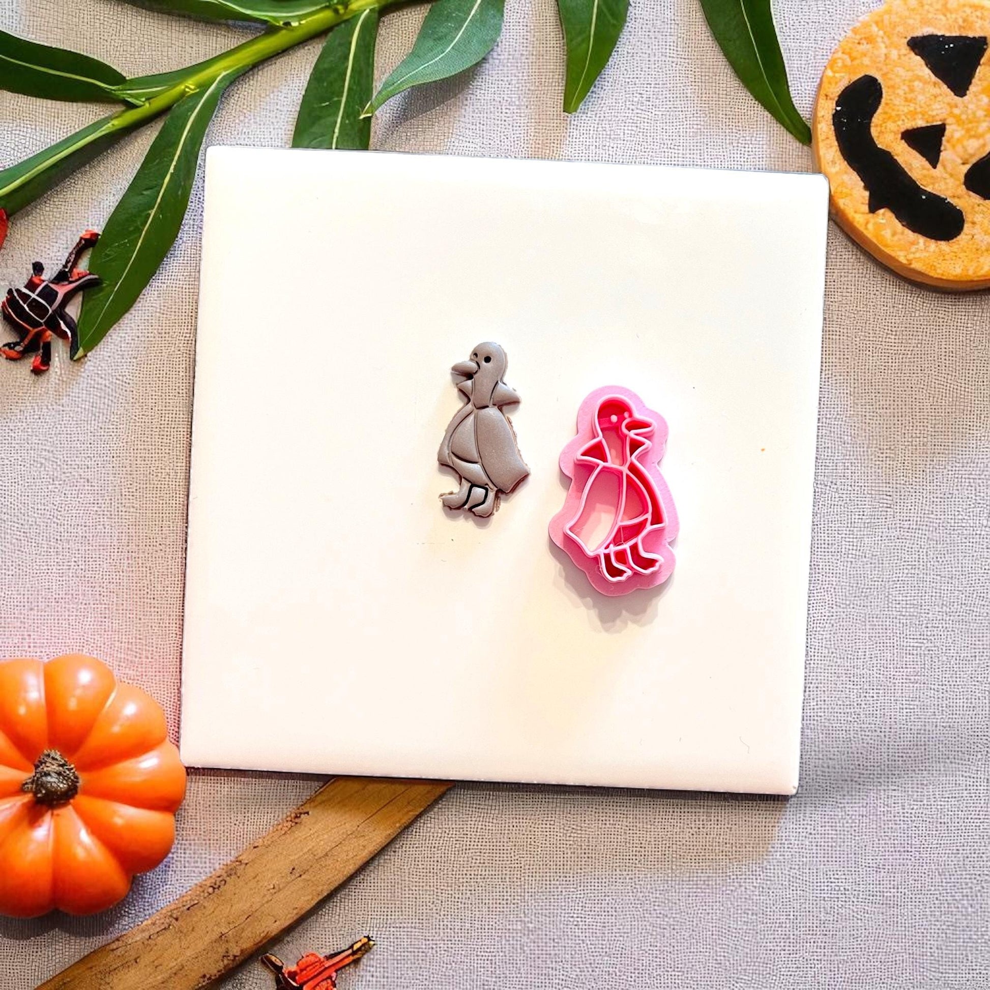 Duckula polymer clay earring next to the pink cutter