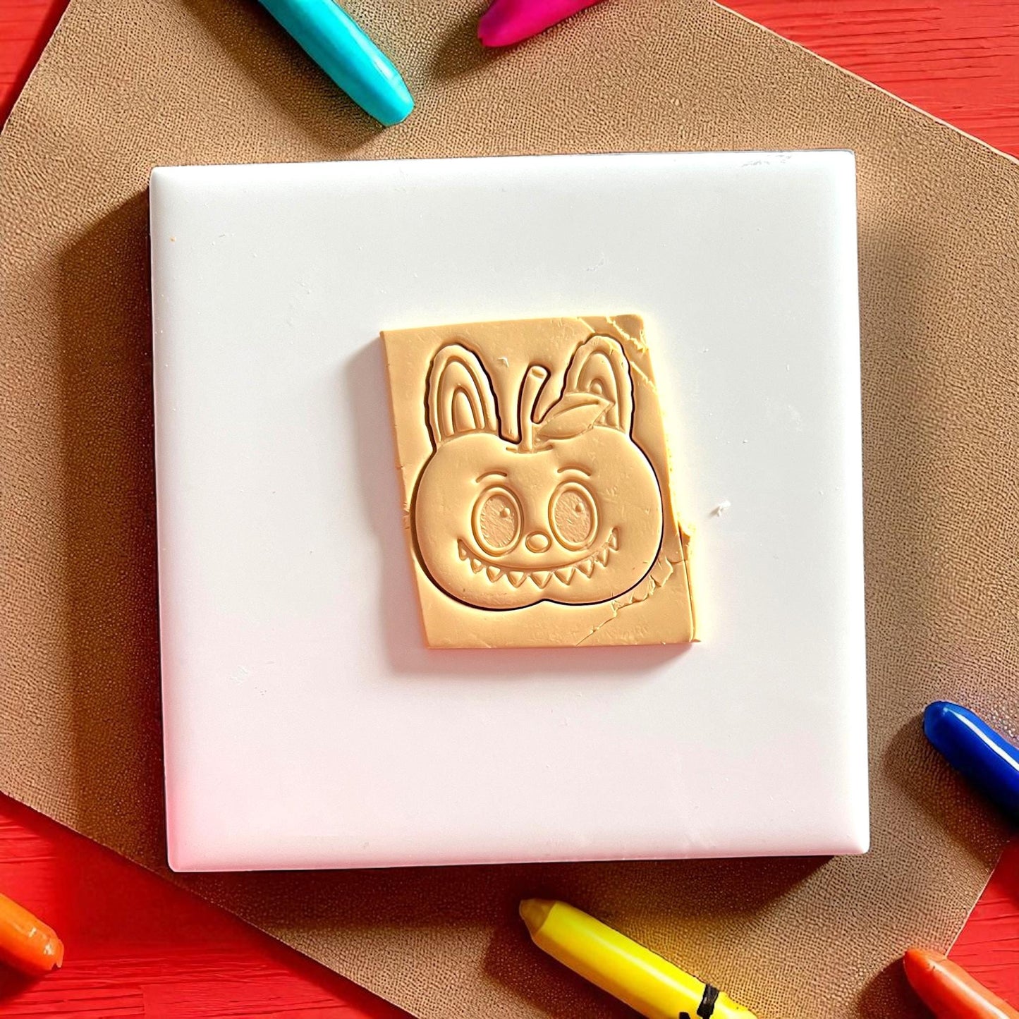 Cheeky apple monster polymer clay cutter with impression on clay