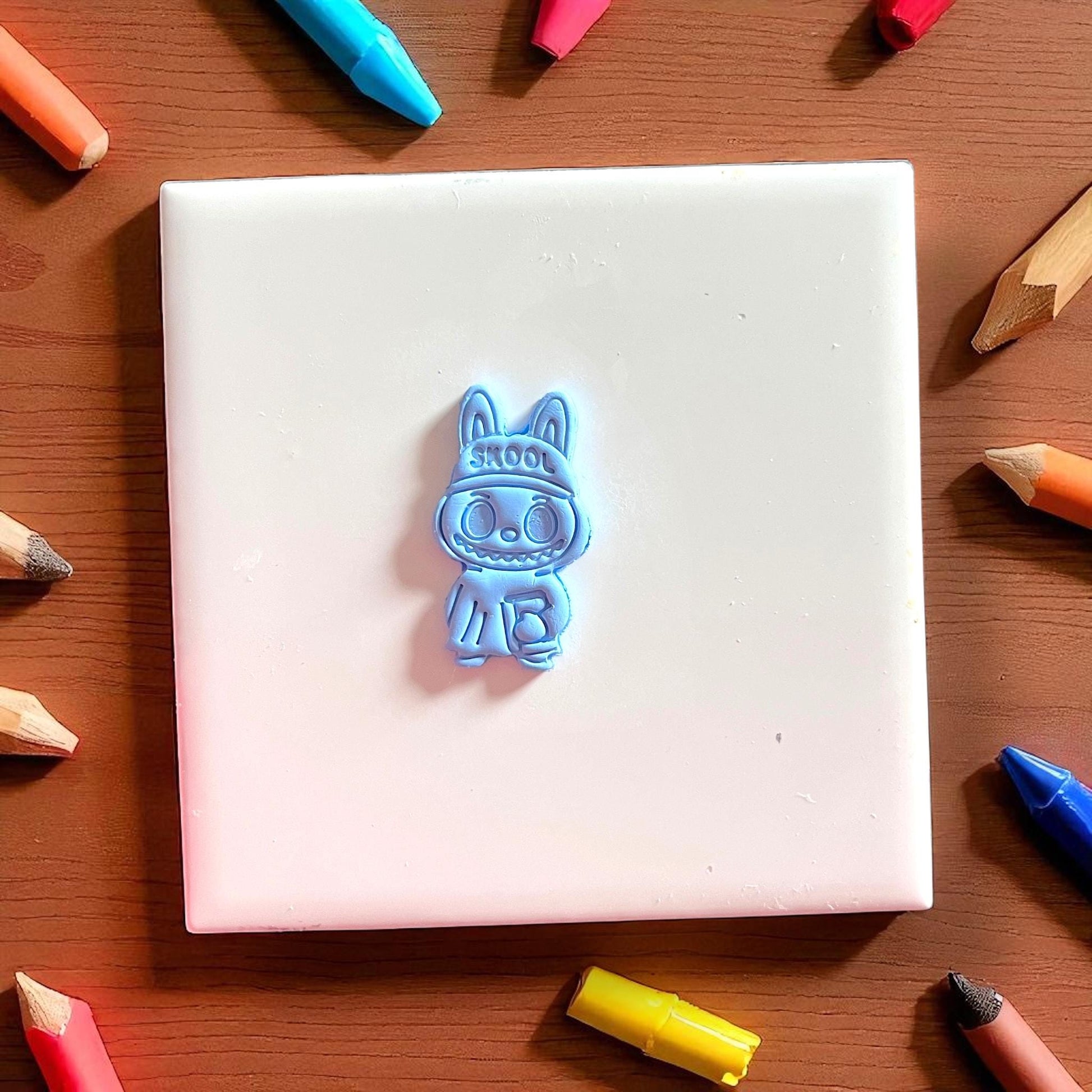 Cute school monster clay impression on blue clay slab with book detail