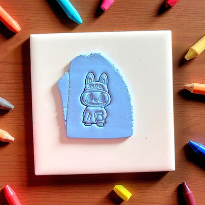 Back to school monster polymer clay cutter holding a book