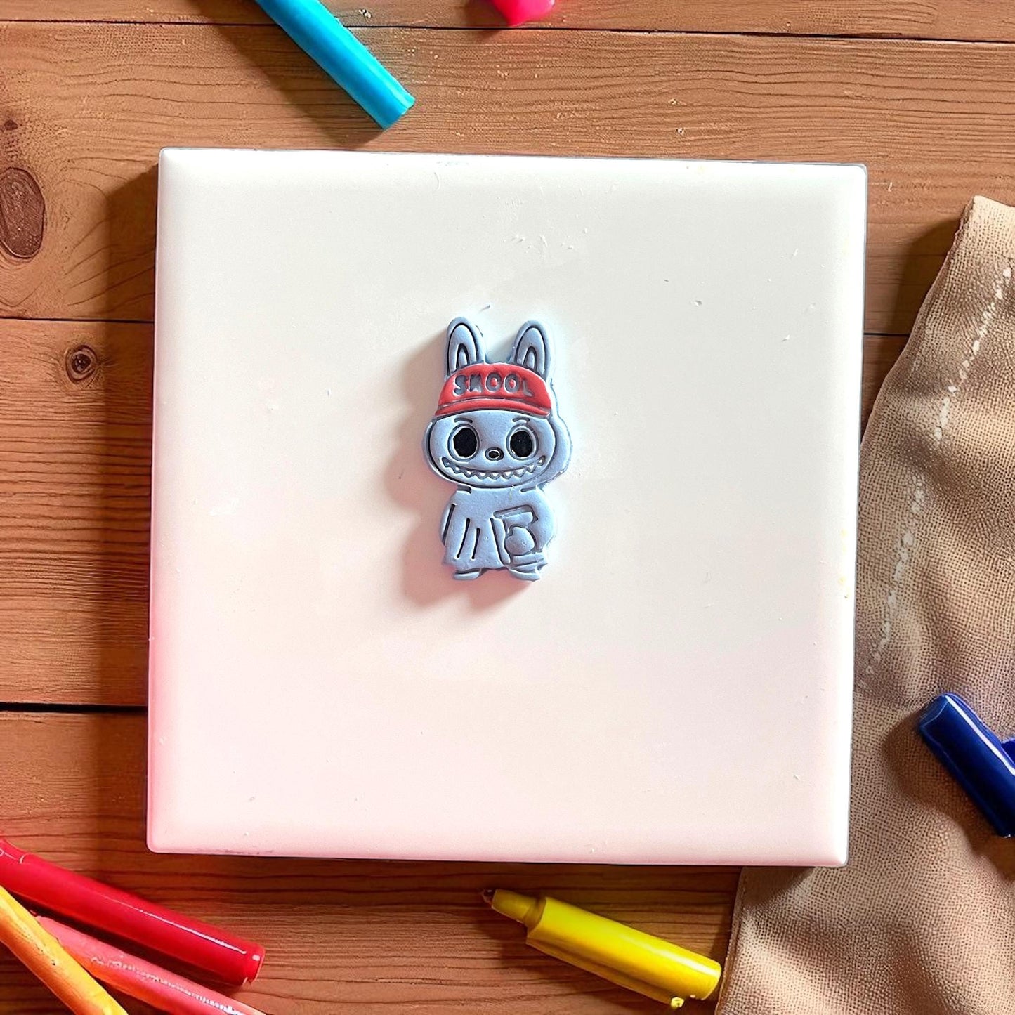 Painted school monster polymer clay piece with book detail