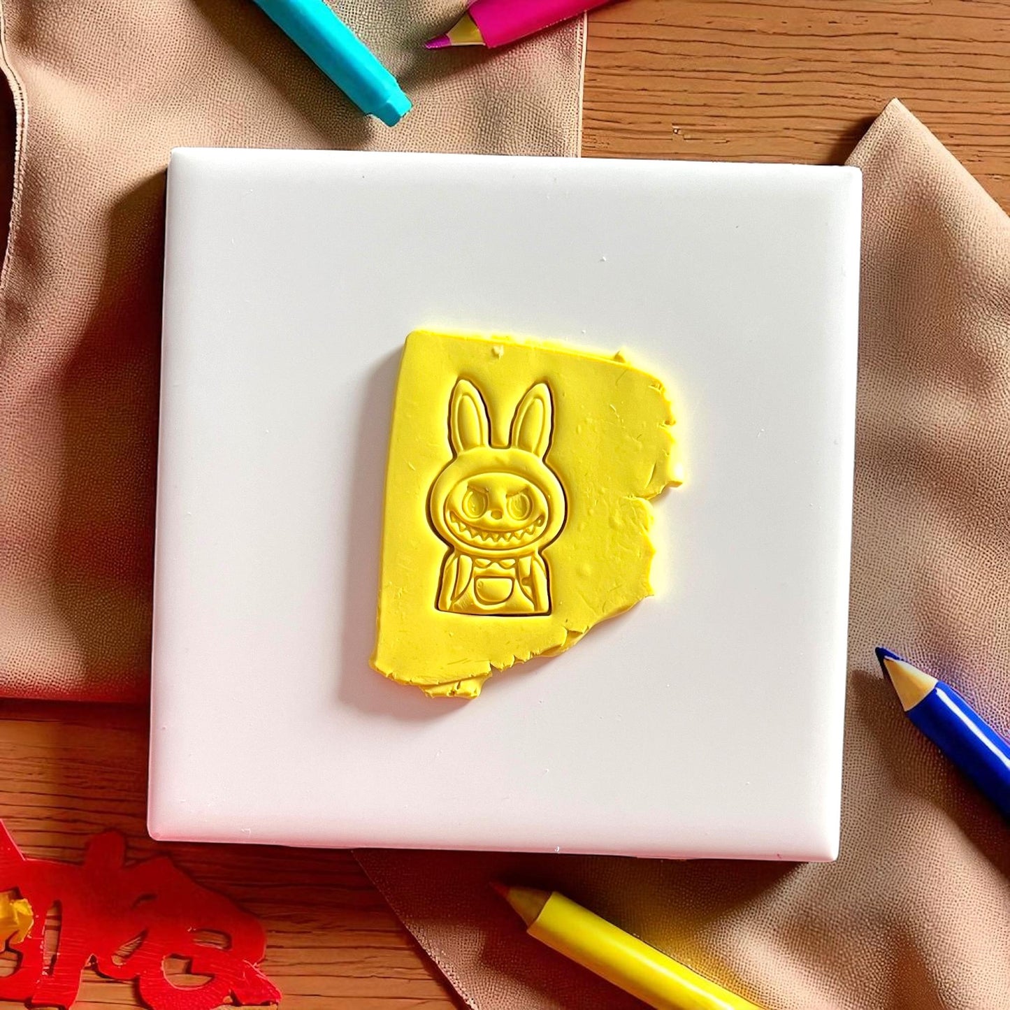 Polymer clay imprint of monster boy character with hoodie and backpack design