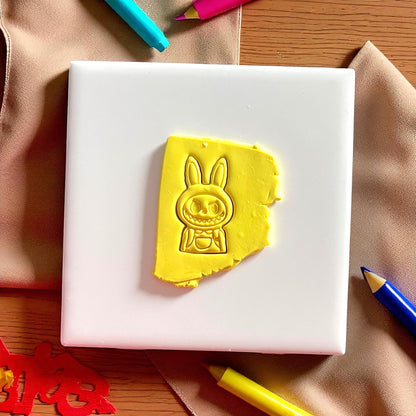 Polymer clay imprint of monster boy character with hoodie and backpack design