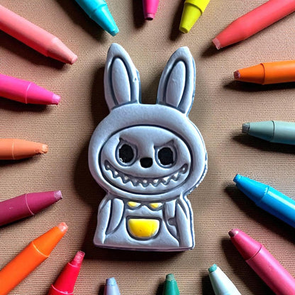 Painted polymer clay charm of monster boy character with yellow backpack detail