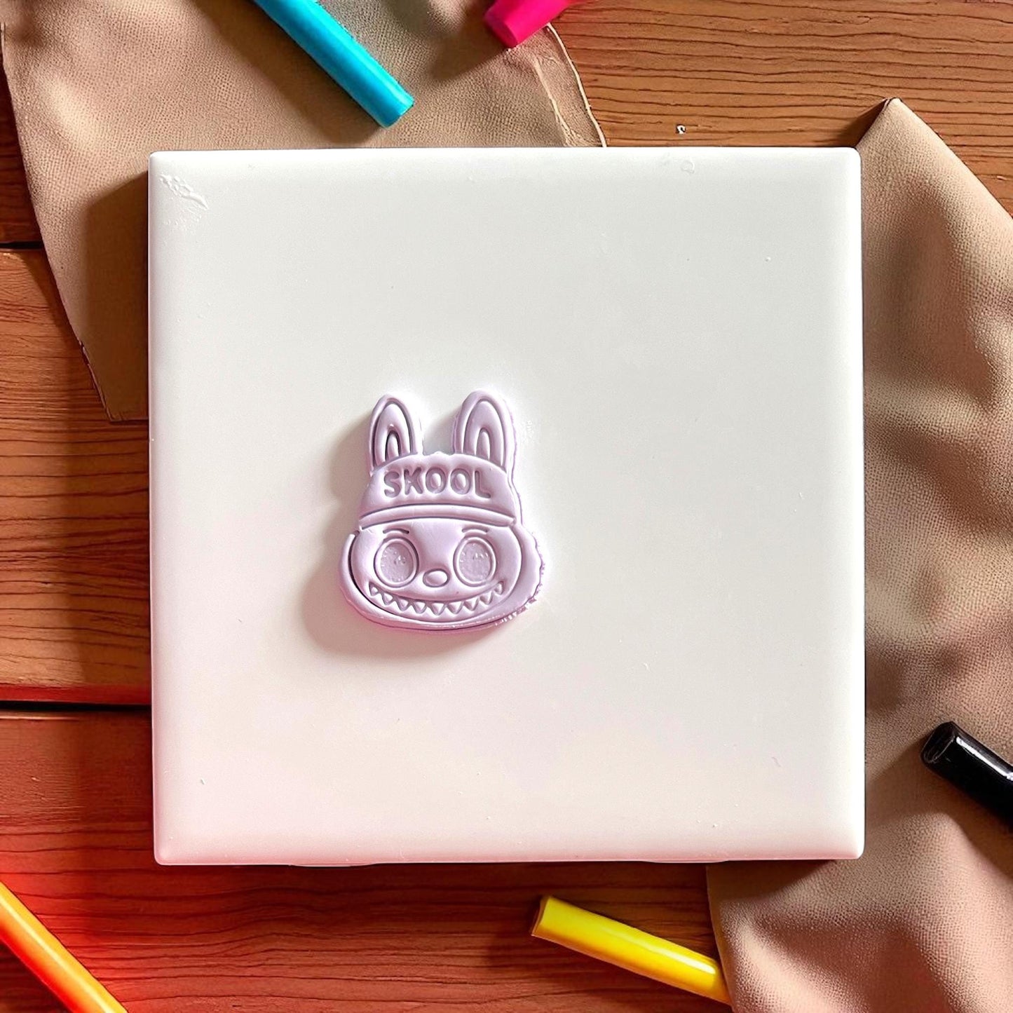 Polymer clay impression of SKOOL hat monster cutter