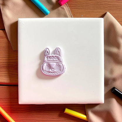 Polymer clay impression of SKOOL hat monster cutter