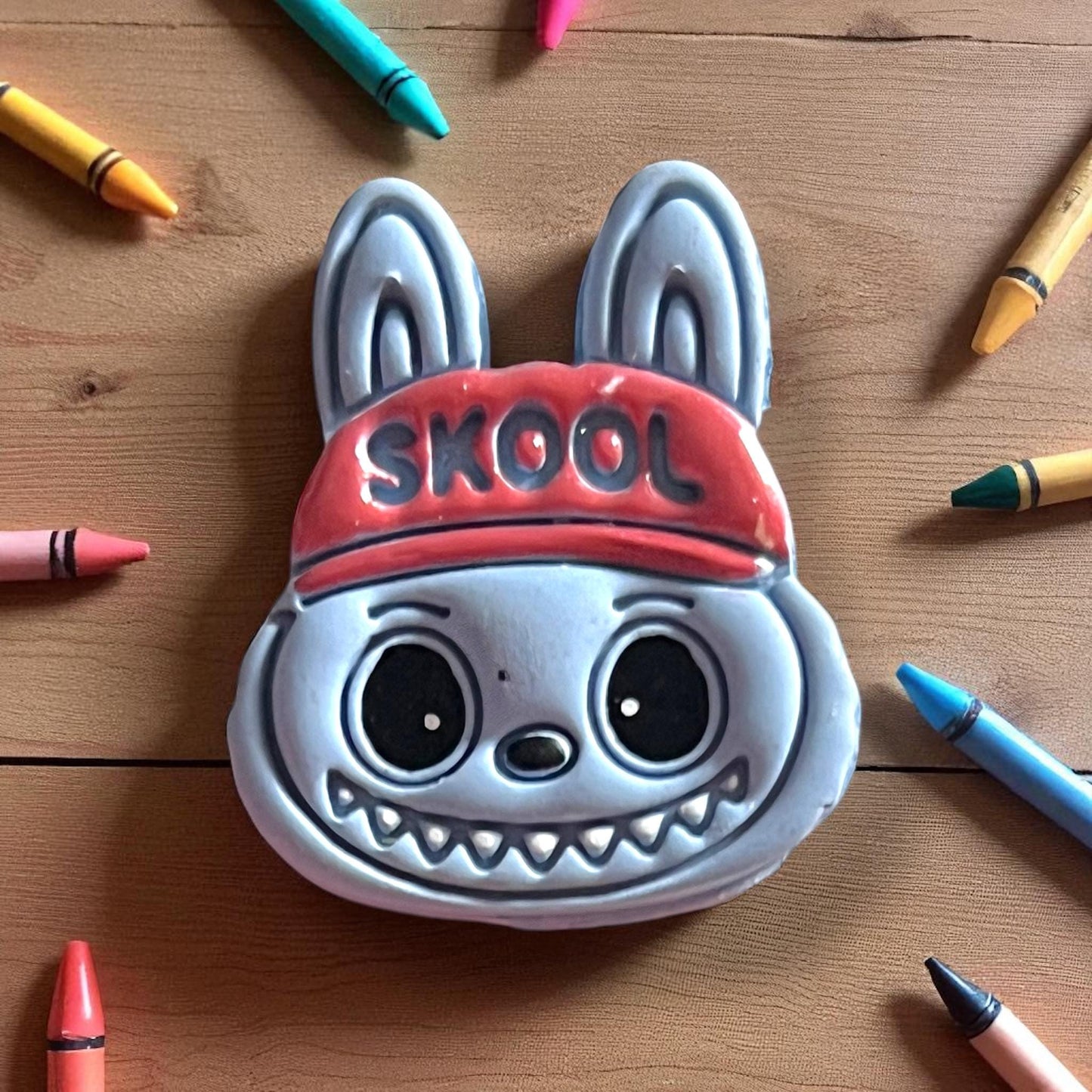 Close-up painted scary cute monster SKOOL hat clay cutter