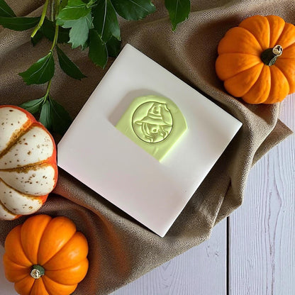 Close-up of sexy witch polymer clay imprint with pumpkins and green leaves