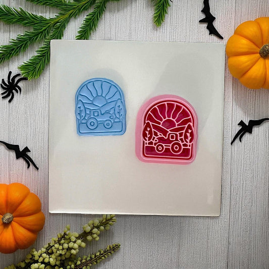 Two tractor sunset clay cutters in blue and pink with Halloween decor