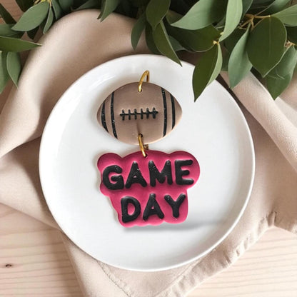 Football Game Day polymer clay earrings displayed on white plate
