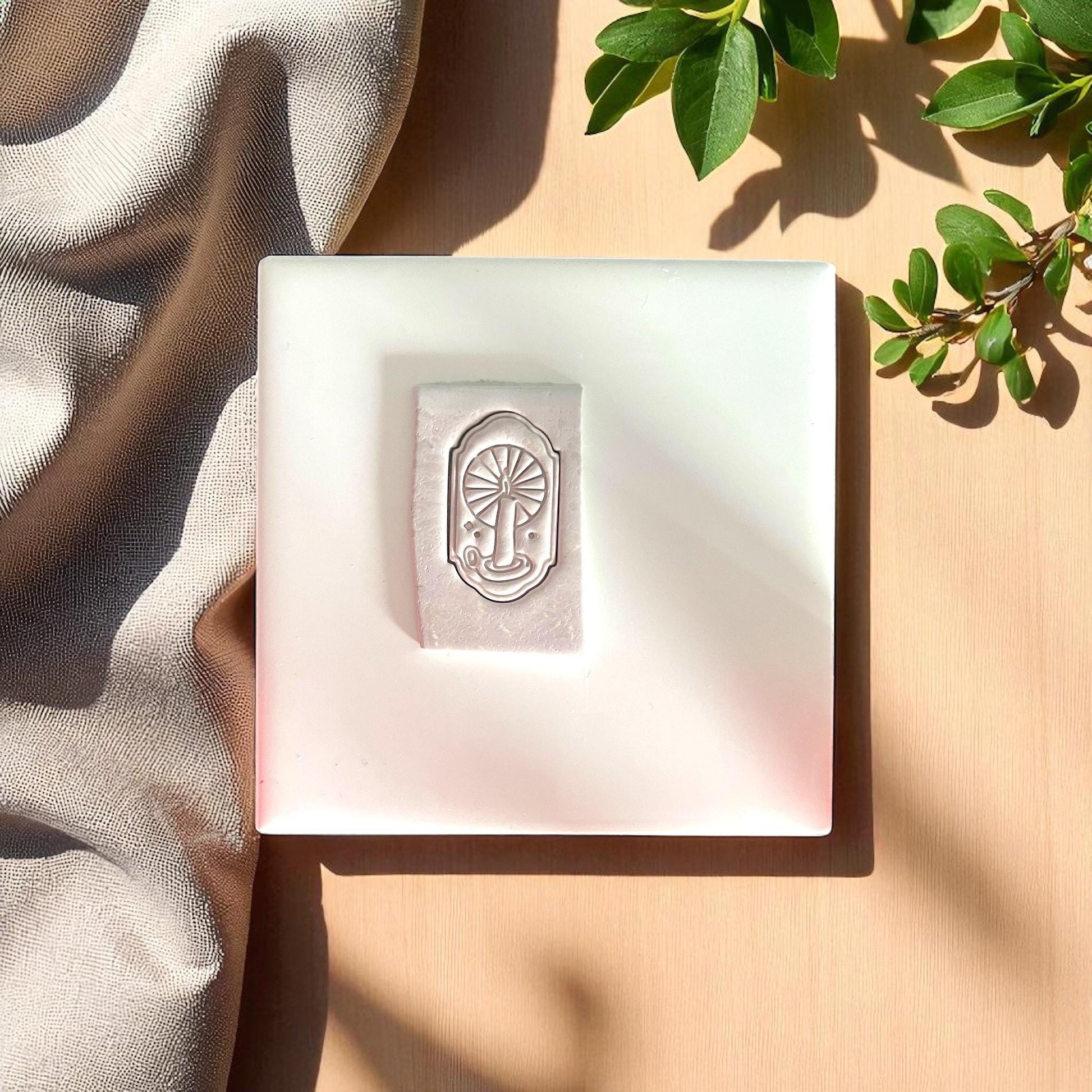 clay impression of candle in arch with sunburst rays