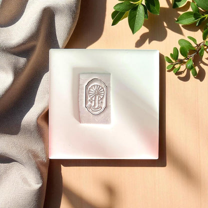 clay impression of candle in arch with sunburst rays