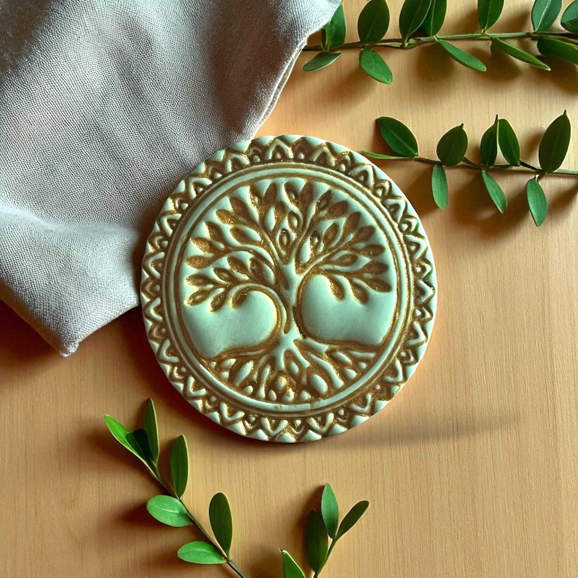 Green clay impression of Tree of Life design with ornate border