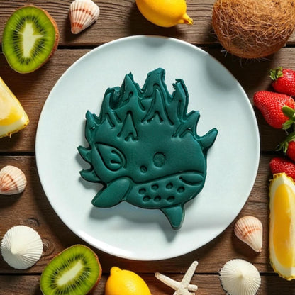 Large pomegranate whale clay design on plate with kiwi and shells