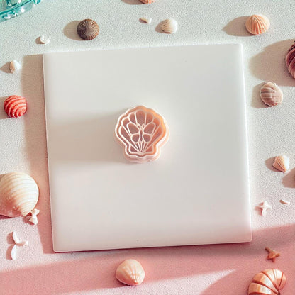 Peach-toned shell butterfly polymer clay cutter on white tile