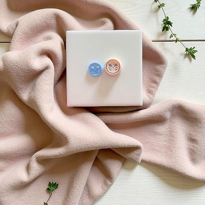 floral stamp charm on soft blush background