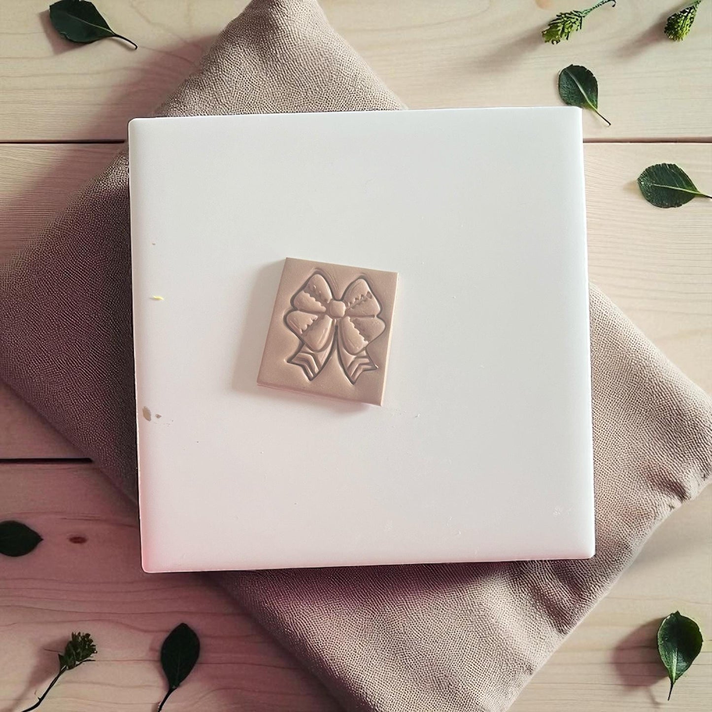 Football ribbon bow polymer clay imprint on white tile