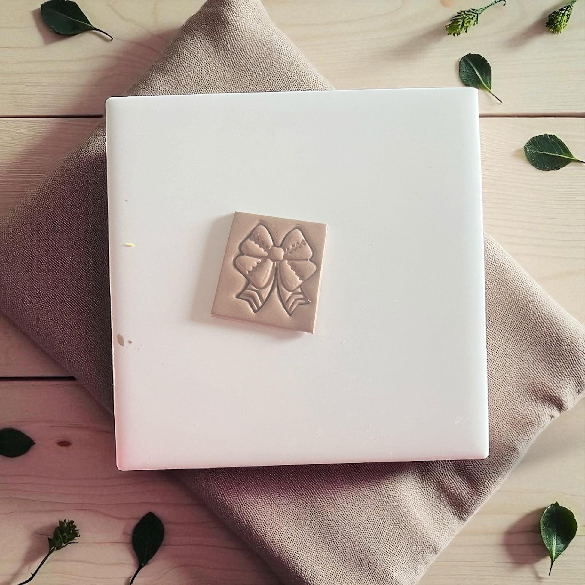 Football ribbon bow polymer clay imprint on white tile