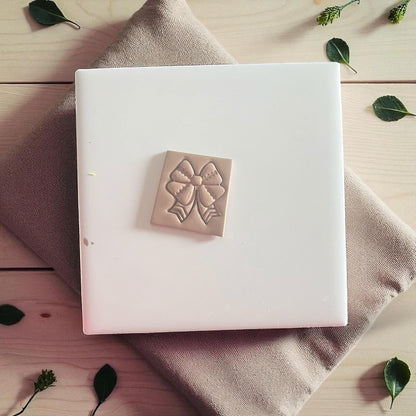 Football ribbon bow polymer clay imprint on white tile