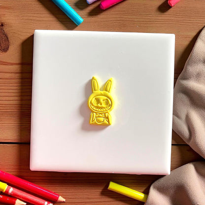 Small polymer clay cutout of monster boy character for school-themed earrings