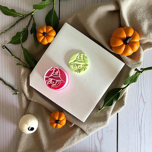 Pink sexy witch cutter and green clay imprint on white tile with pumpkins