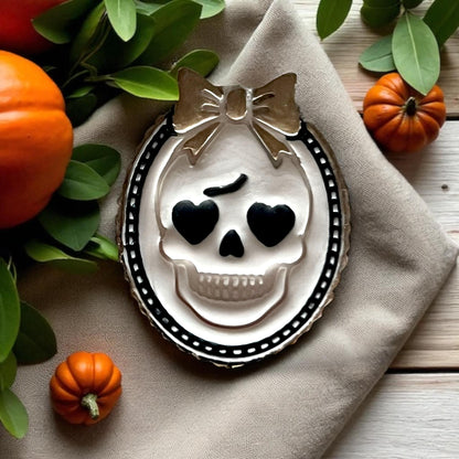 Close-up of decorated girly skull cameo cookie with heart eyes and bow