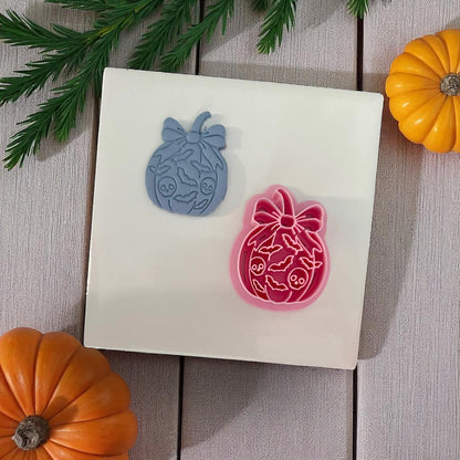 Blue pumpkin bow clay cutter and pink cutter on display tile