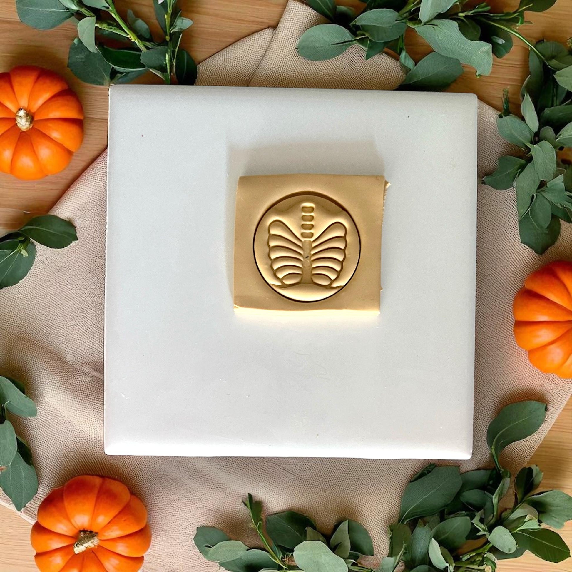 Golden ribcage skeleton clay design on white tile