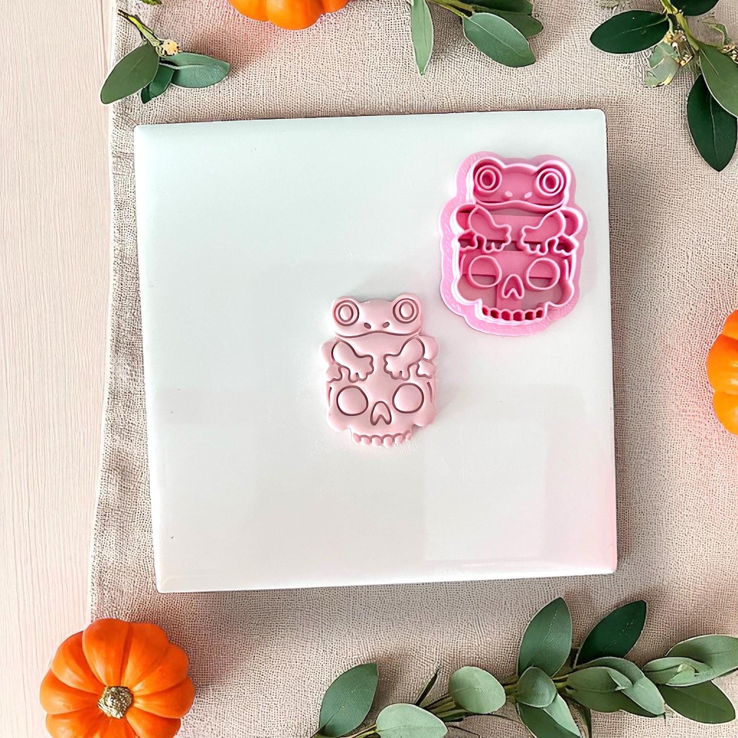 Frog on skull clay cutter next to pink clay piece