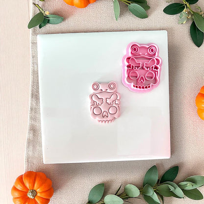 Frog on skull clay cutter next to pink clay piece