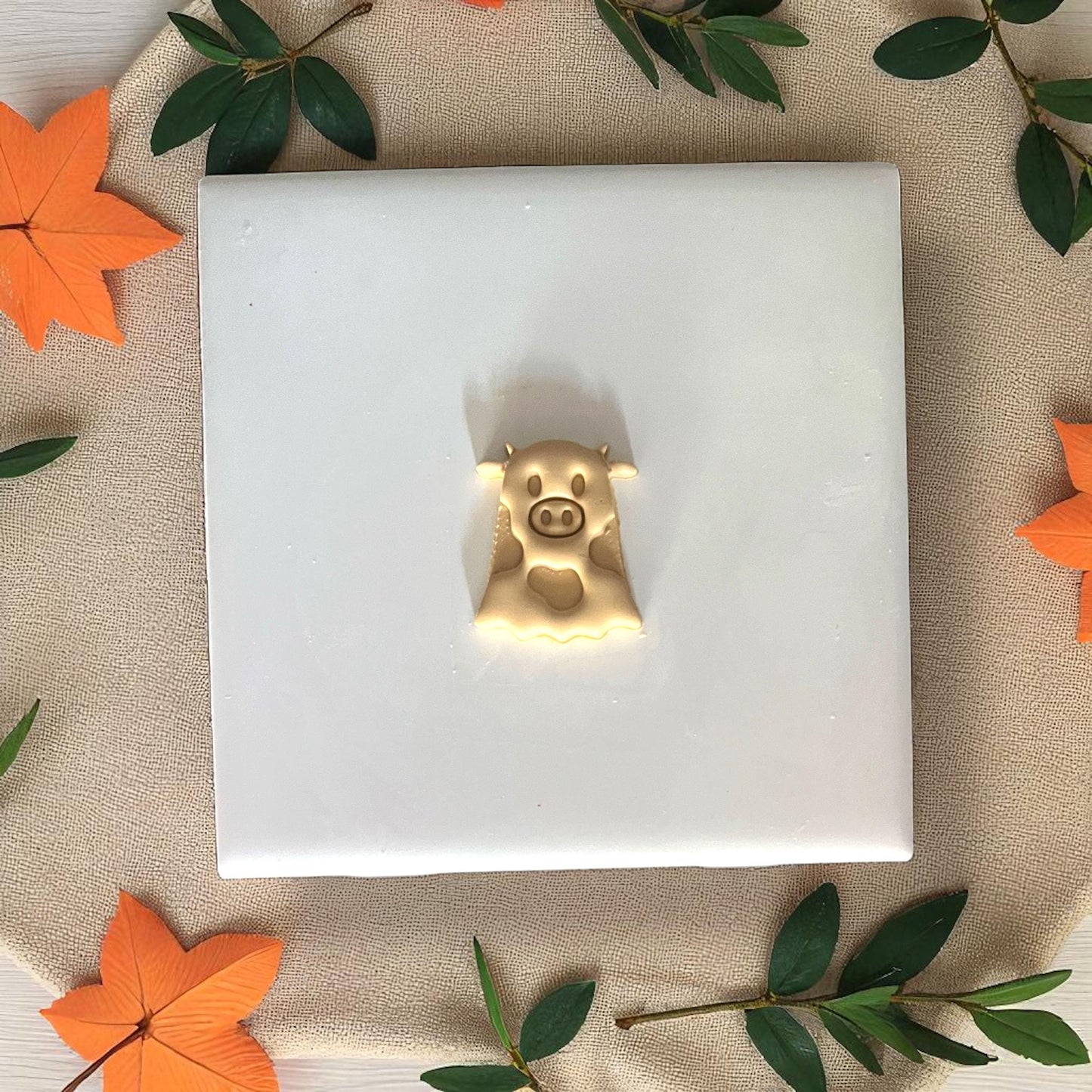 Golden ghost cow clay impression on white tile