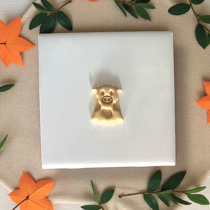 Golden ghost cow clay impression on white tile