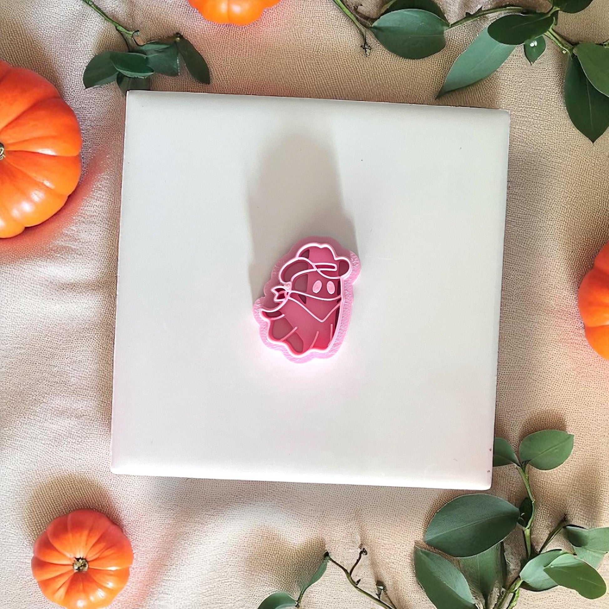 Cowboy ghost pink cutter on white tile with pumpkins