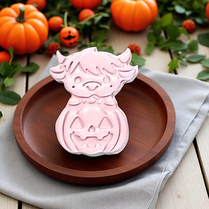 Clay impression of highland cow on pumpkin on wooden plate
