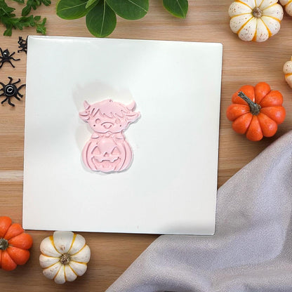 Pink highland cow pumpkin clay piece surrounded by mini pumpkins