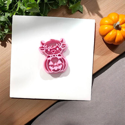 Pink highland cow pumpkin clay cutter on tile