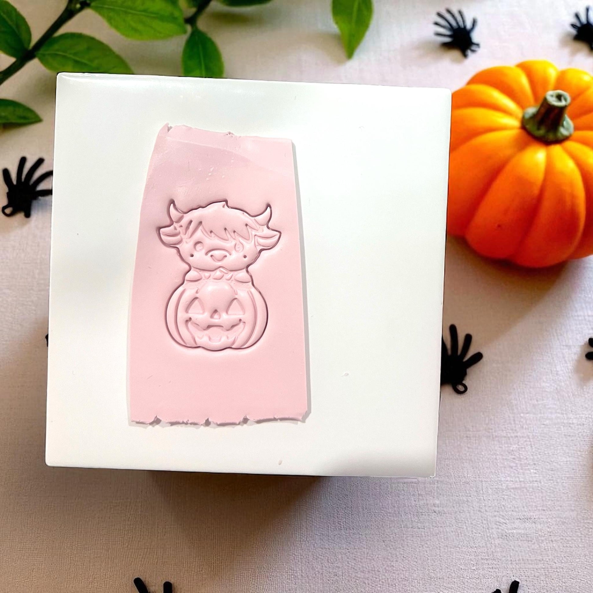 Pink highland cow pumpkin clay cutter on tile