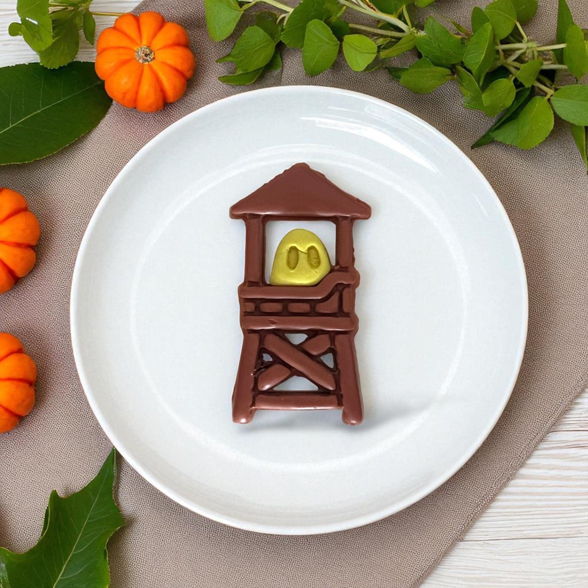 Empty ghost lifeguard tower cutters on a white tile surrounded by pumpkins.