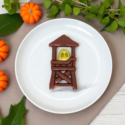 Empty ghost lifeguard tower cutters on a white tile surrounded by pumpkins.