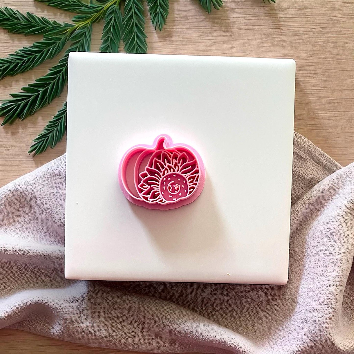 Pink sunflower pumpkin clay cutter on fabric