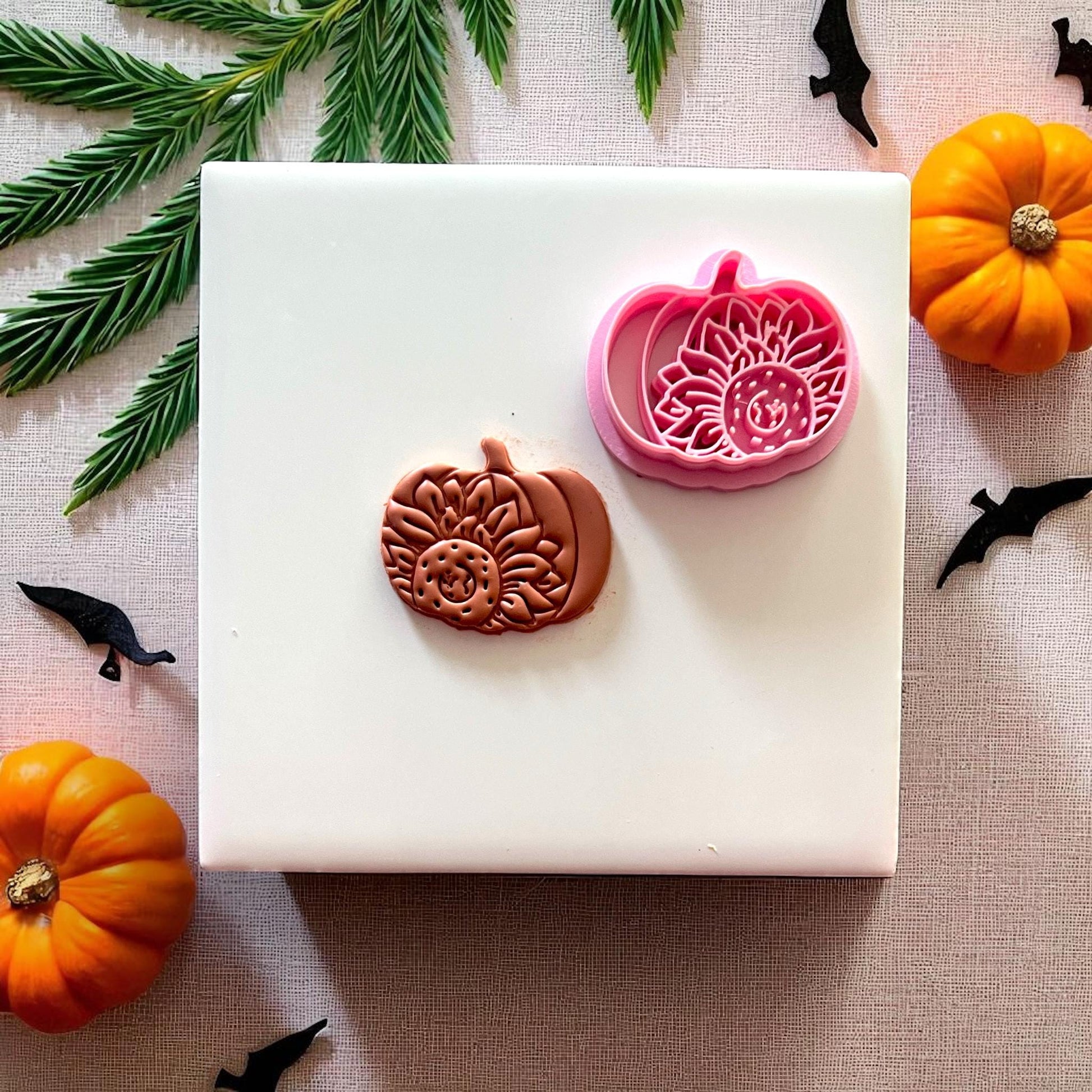 Cutter and clay sunflower pumpkin design on white tile
