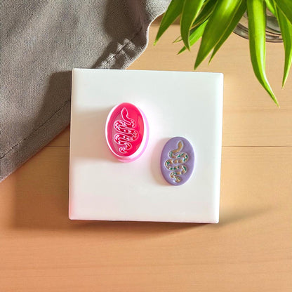 Pink snake clay cutter with purple clay snake design